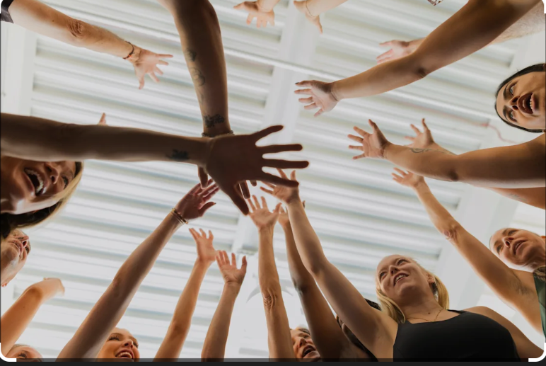 F45 members celebrating together with a group high five after class